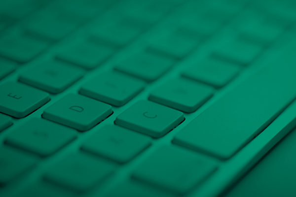 An image of a computer keyboard close-up with green effect