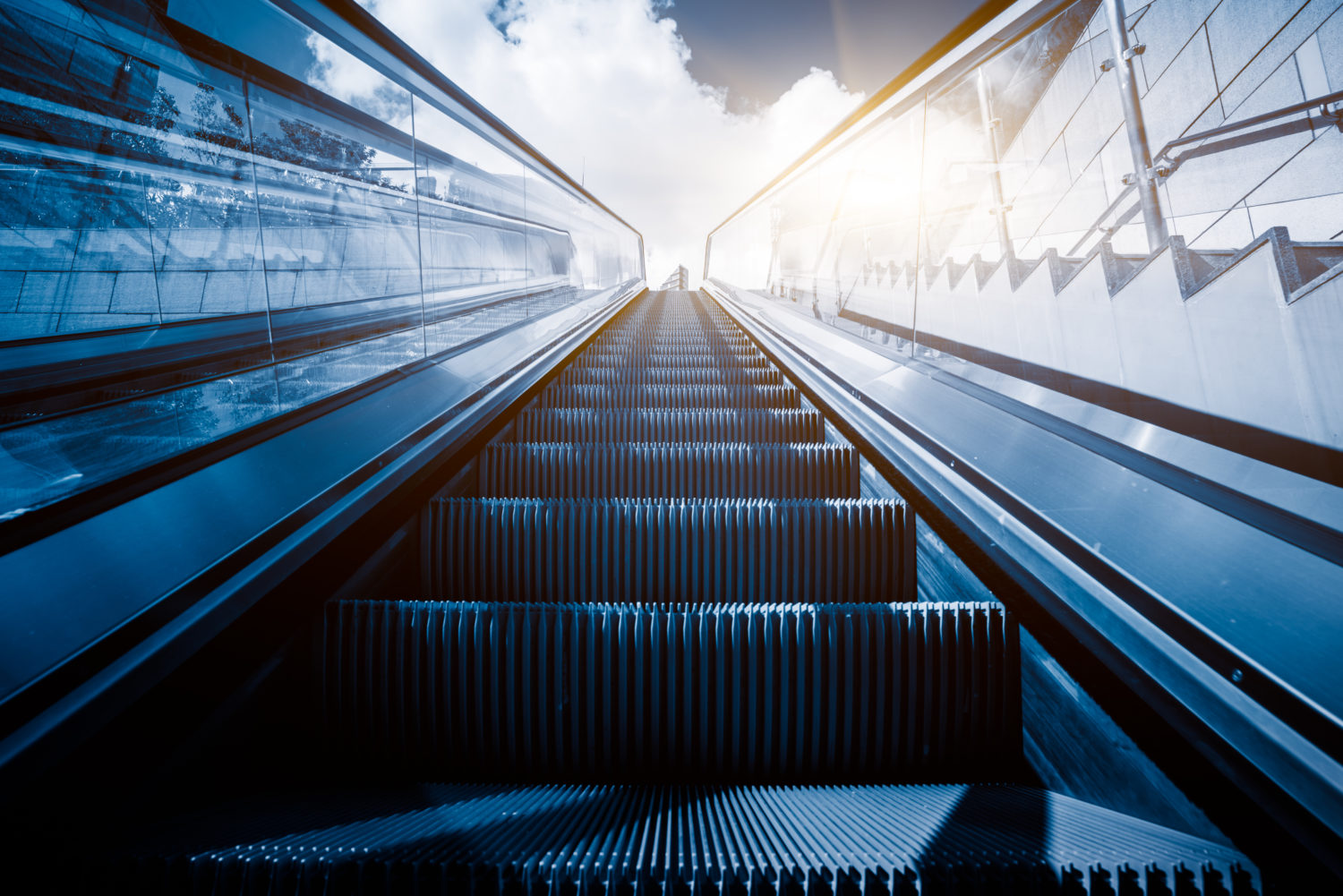 Escalator in an underground station with skyline in background.