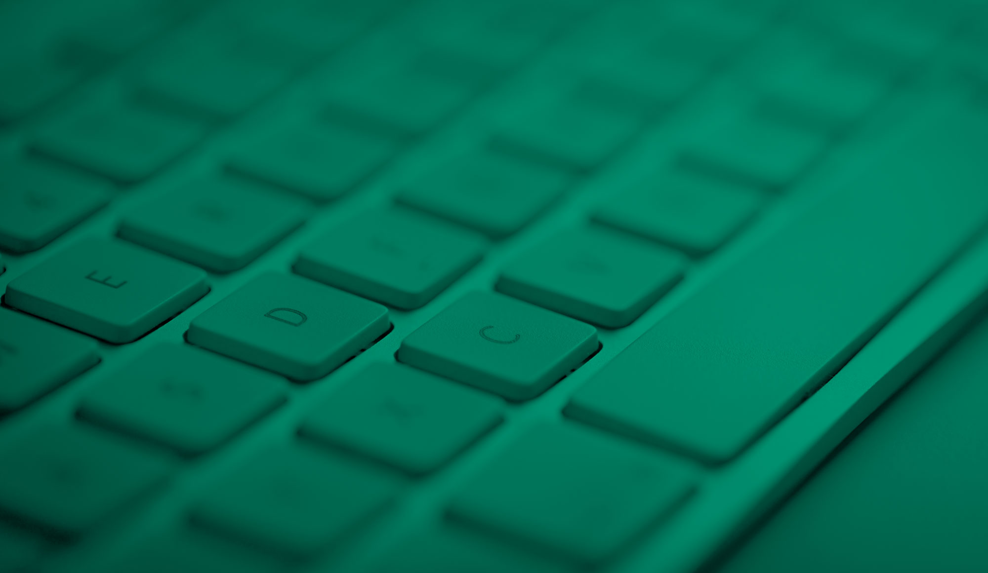 An image of a computer keyboard close-up with green effect