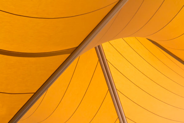 A close-up of yellow sails used to provide solutions at the forecourt entranceway