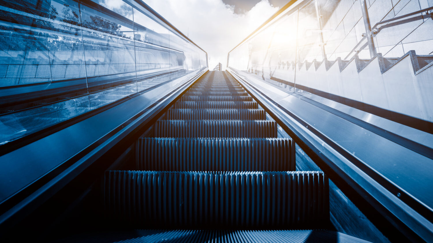 Escalator in an underground station with skyline in background.