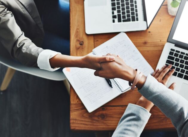 Handshake at desk, representing partnership with Bravura technology for wealth and funds management - hero image